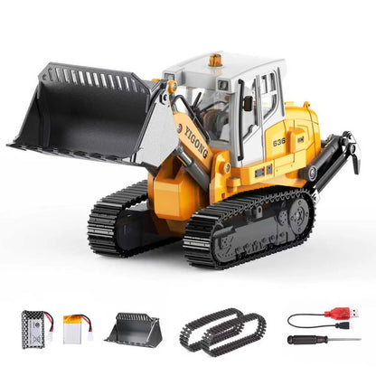 Yigong 636 remote control crawler loader toy model with swappable metal bucket, spare tracks, and USB charging cable.